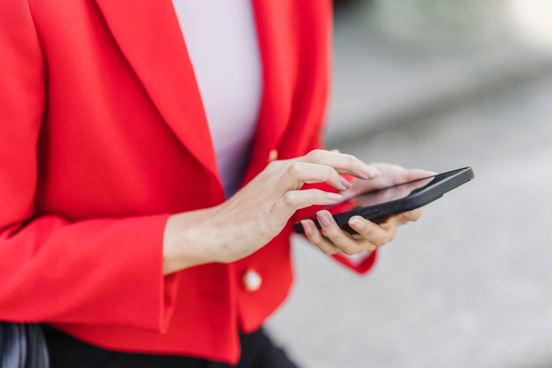 Frau im roten Blazer mit einem Tablet in der Hand